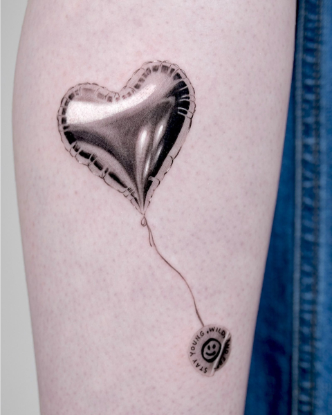 2026 tattoo trends microrealism  chrome balloon tattoo on arm